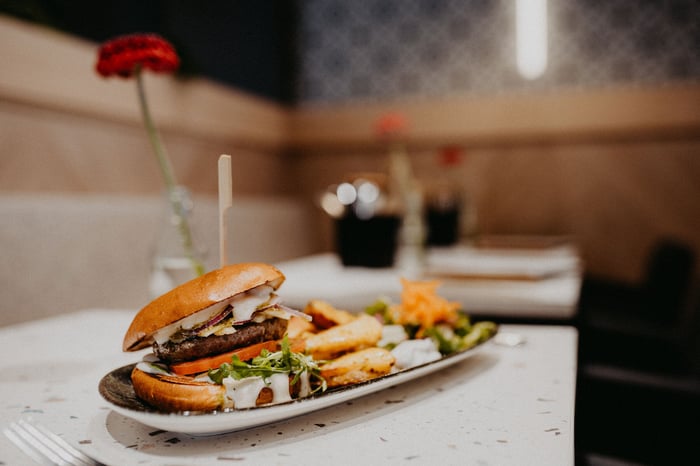 schön angerichteter teller mit burger und beilagen auf einem tisch ohne gäste bei alex kitchen