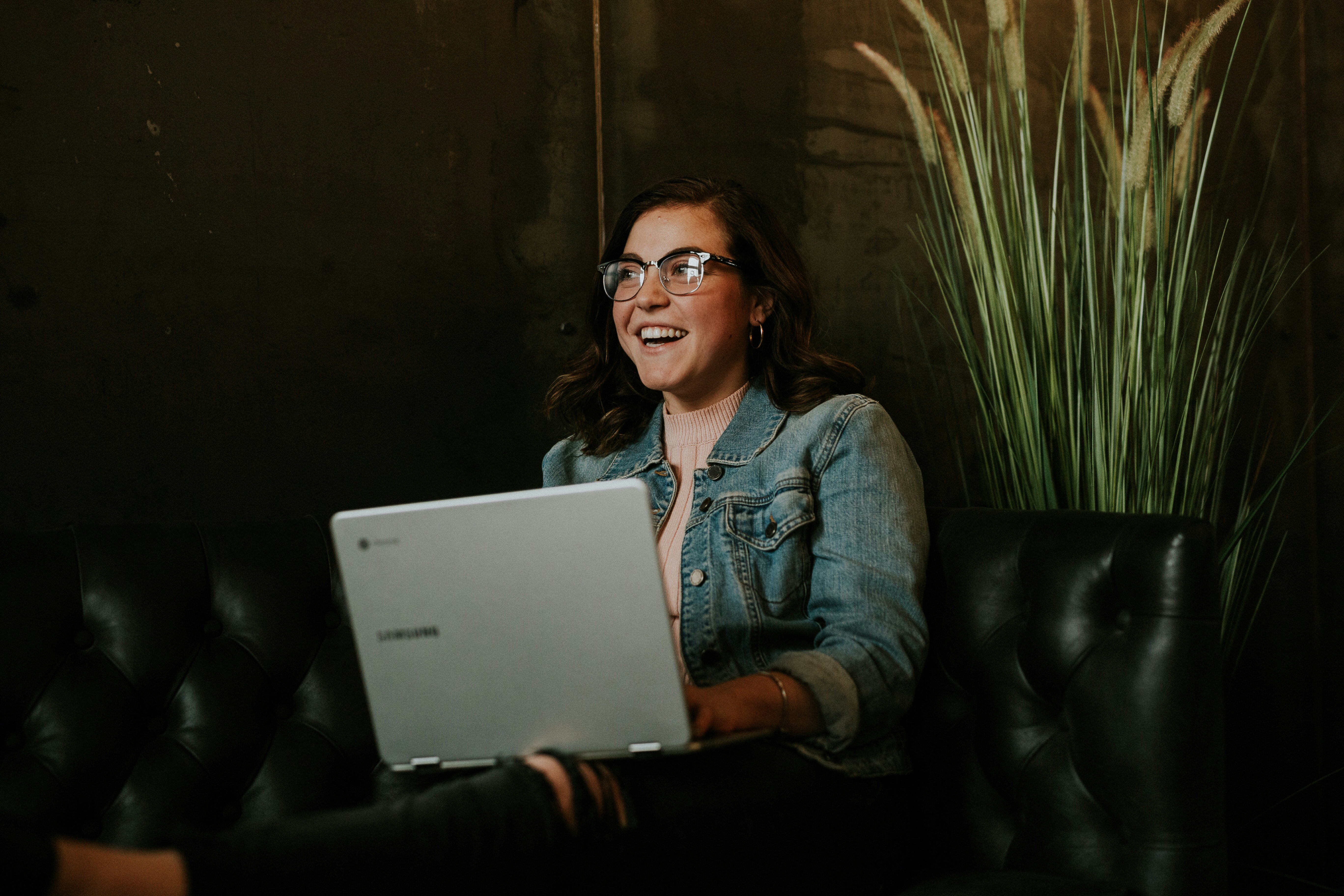 Lachende Frau arbeitet and einem Laptop