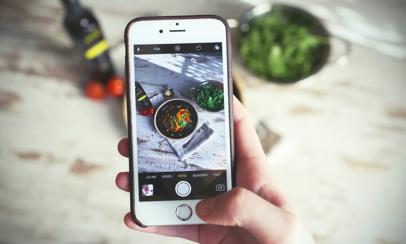 A photo of a beautifully presented dish is taken with a smartphone