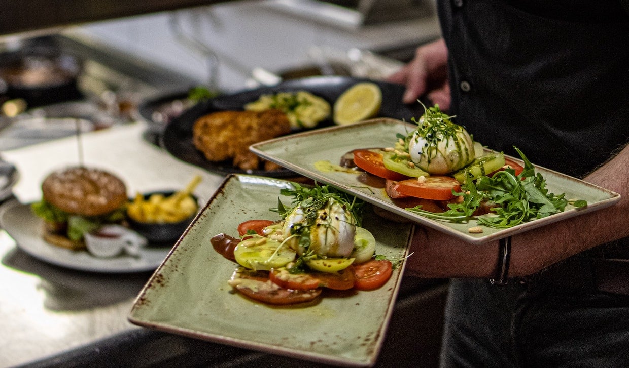 Waiter serving dishes in restaurant