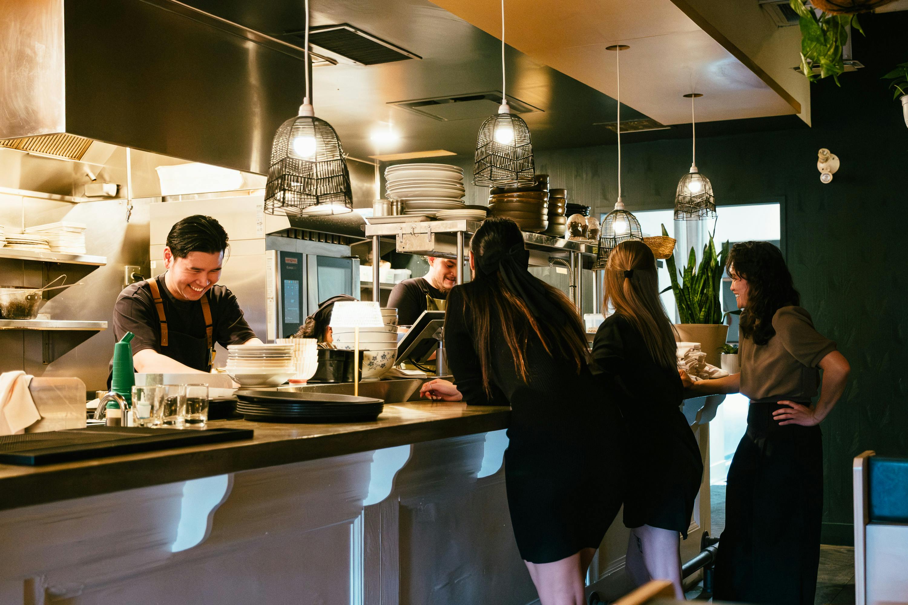 team aus zwei mitarbeitern in einer restaurantküche, die gemeinsam mit den gästen lachen