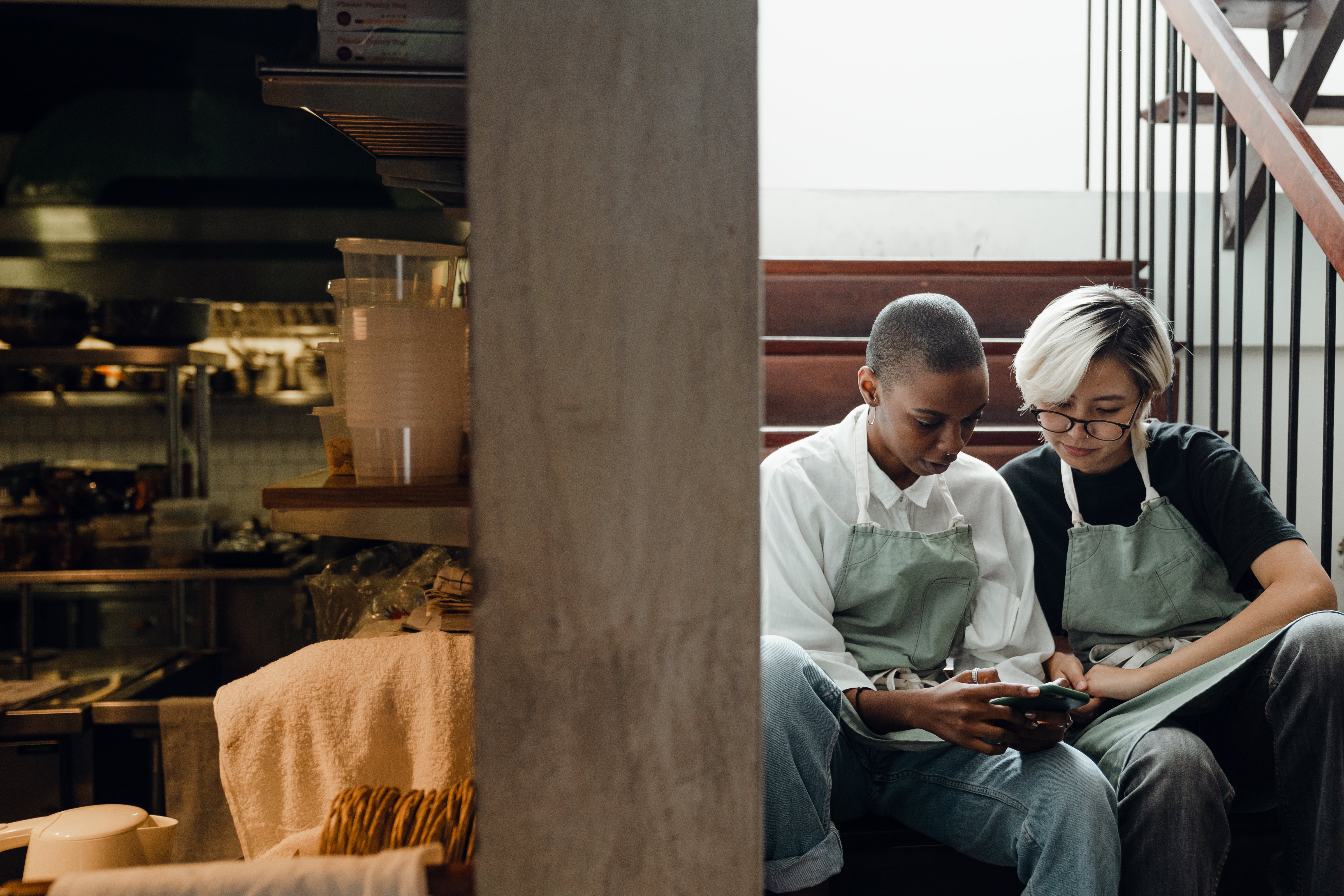 two employees scrolling through a cell phone