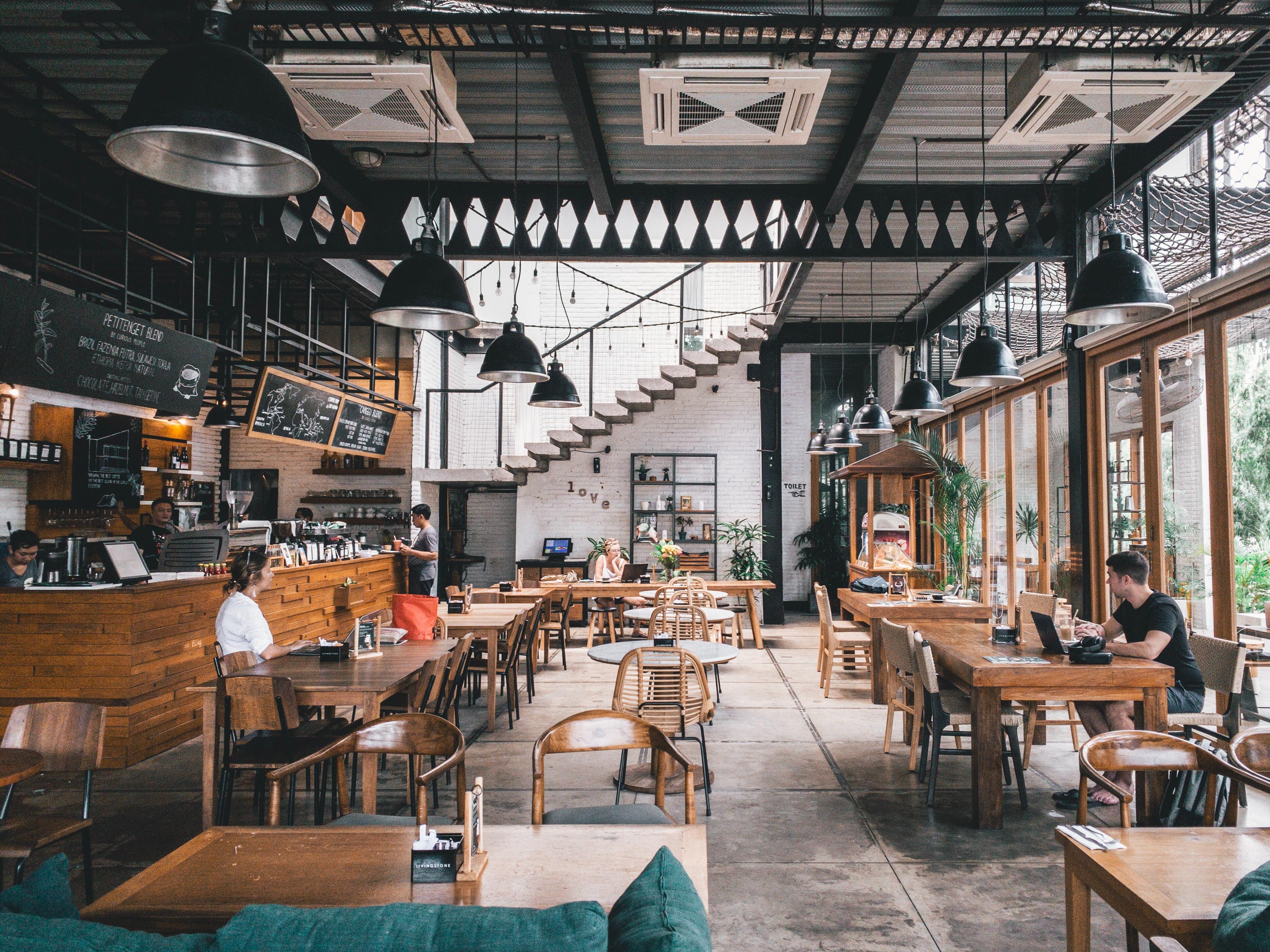 A bright restaurant with guests at the tables and staff behind the counter.