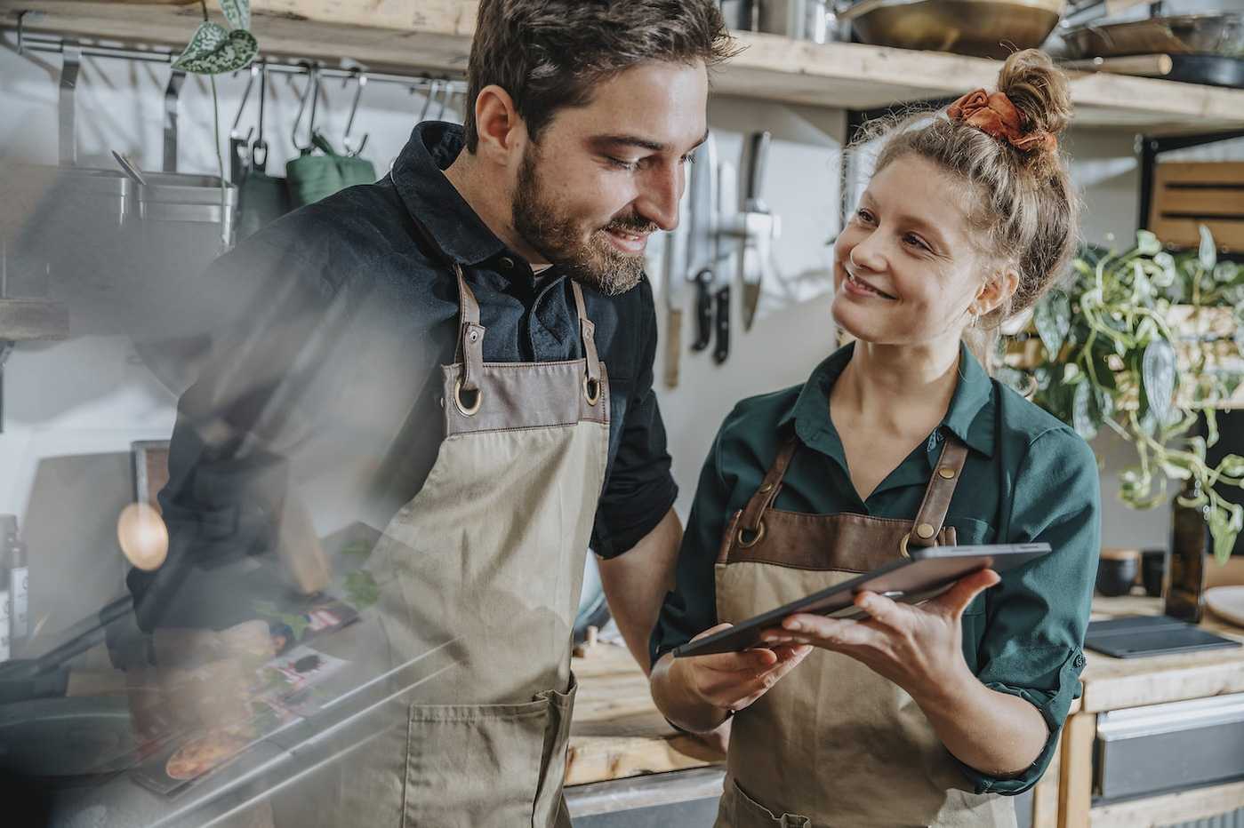 Mitarbeiter in Gastronomie schauen auf Tablet