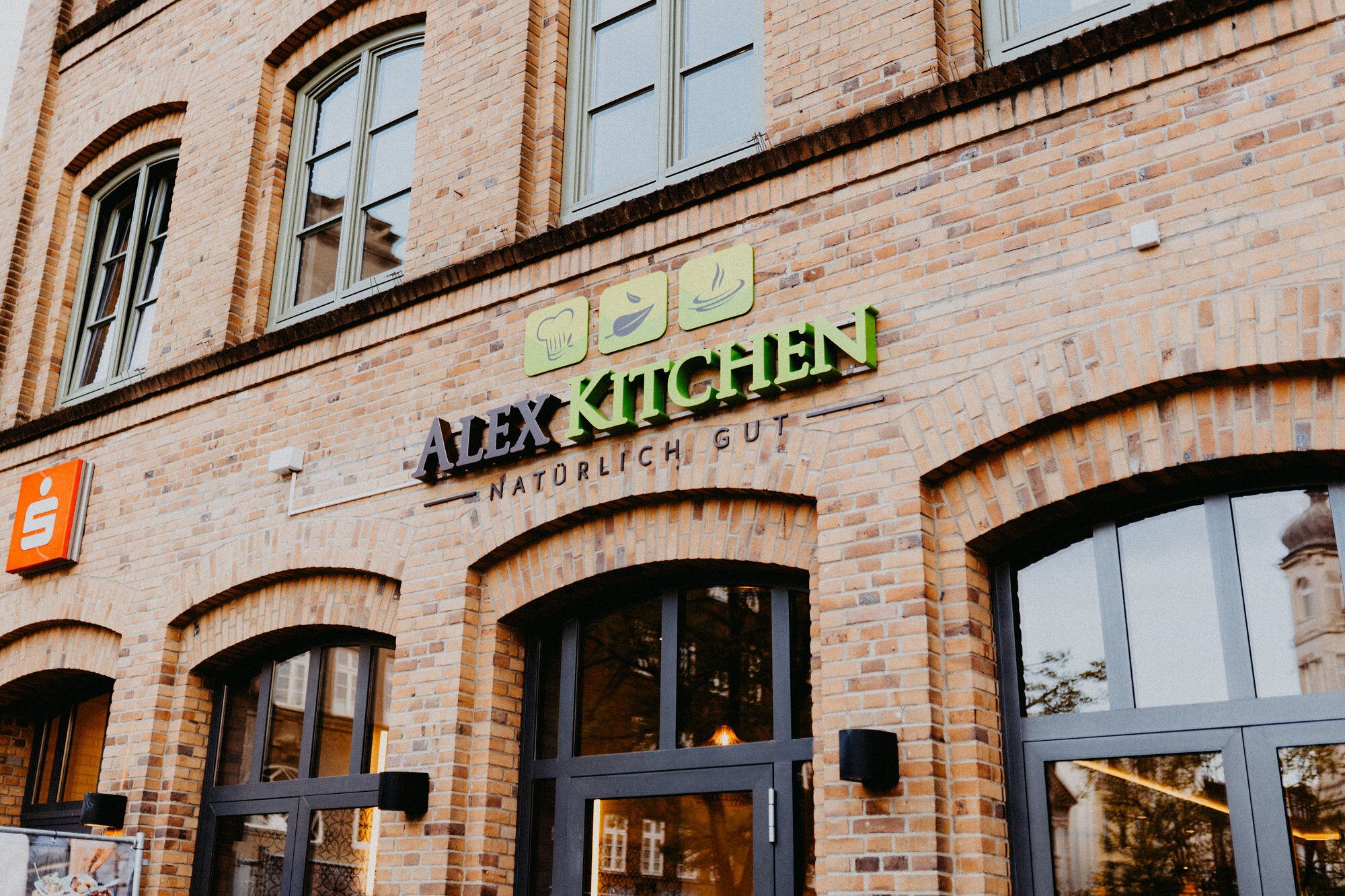 eingangsbereich von alex kitchen in flensburg mit logo