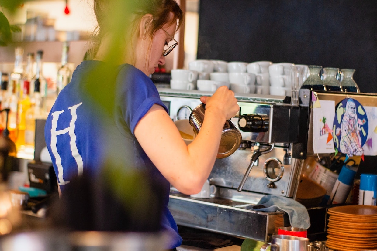 Barista gießt Kaffee in eine Tasse