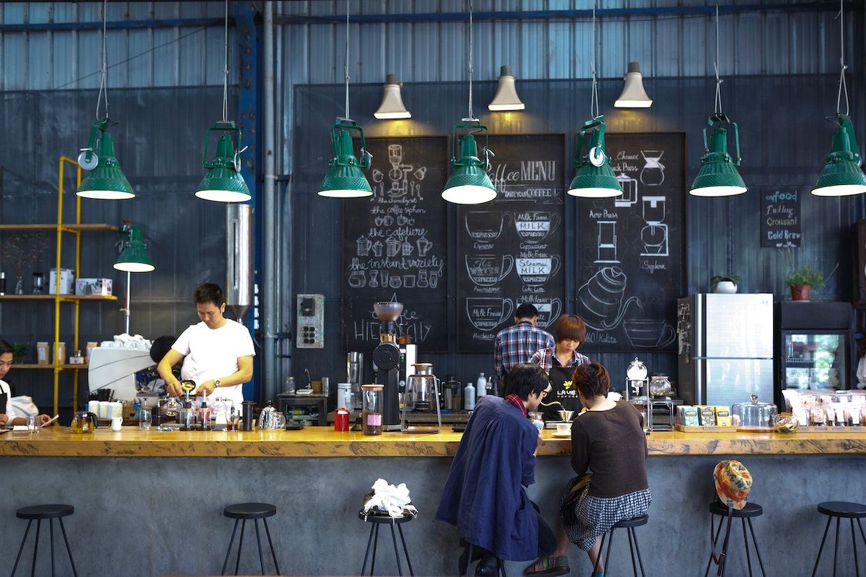 Theke in einem Cafe mit Gästen und Mitarbeiterinnen