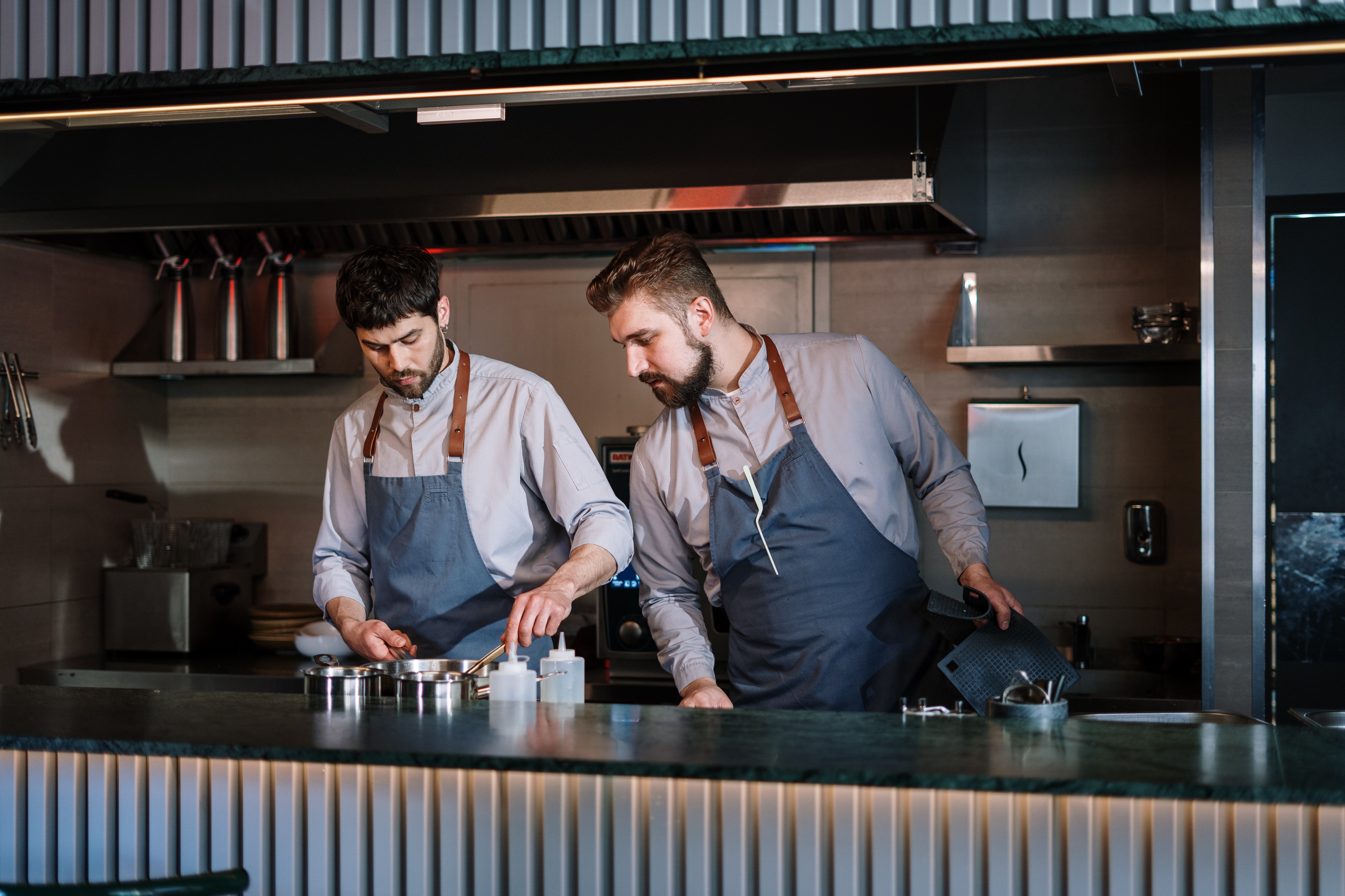 Two employees are cooking together in the kitchen