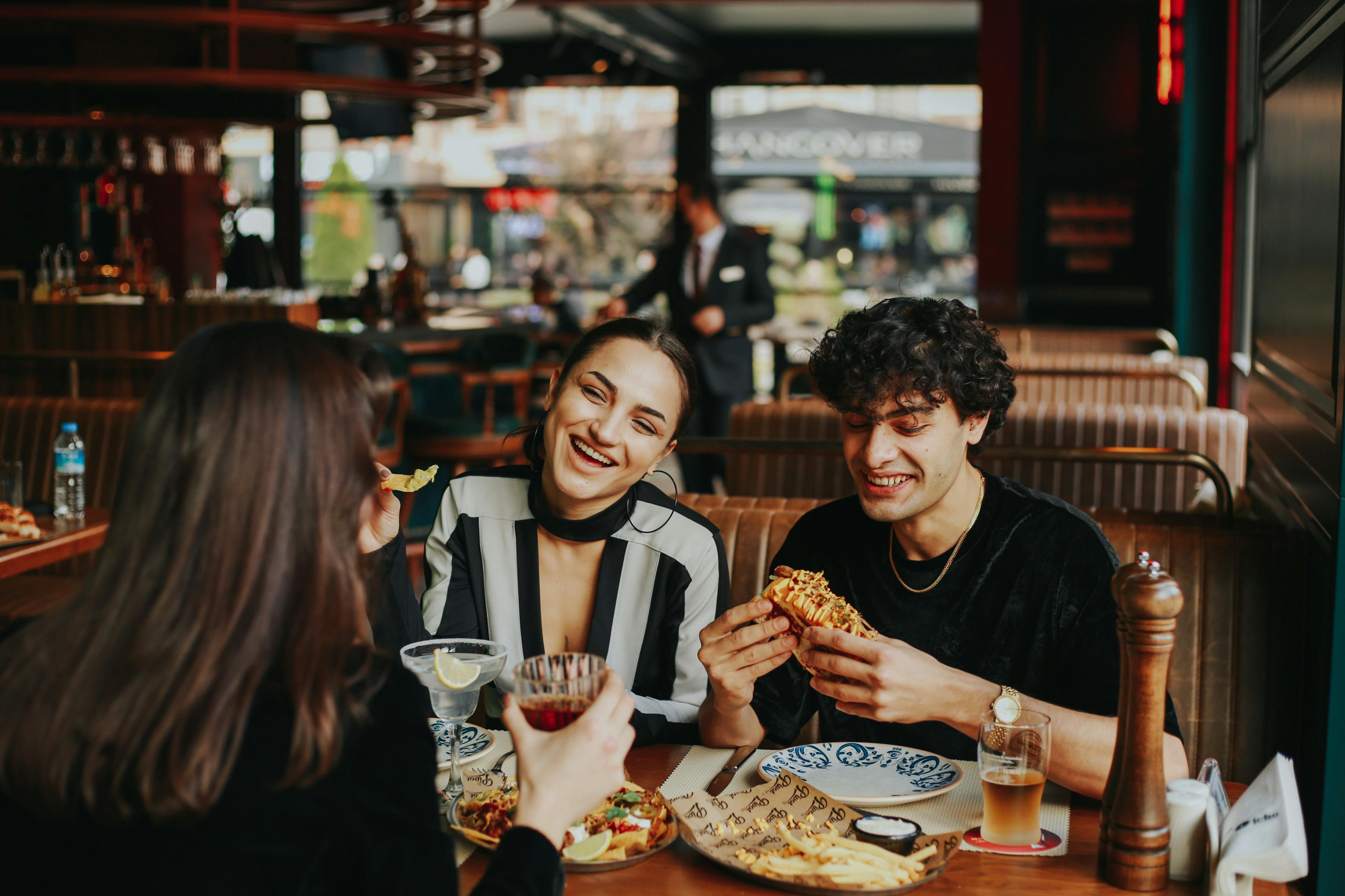 Laughing guests sit together in the restaurant and enjoy their meals
