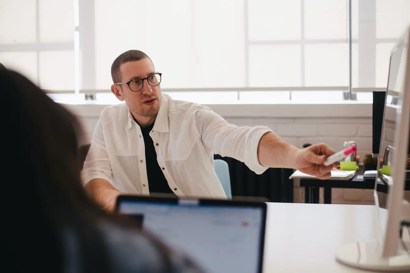 Image of person pointing to a screen in meeting